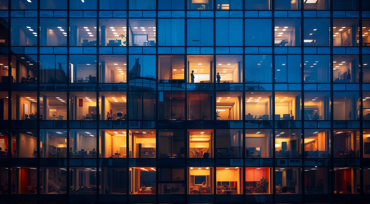 Grid of lit office tower windows at dusk