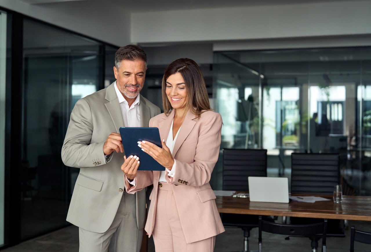 Two colleagues reviewing a product demo on a tablet