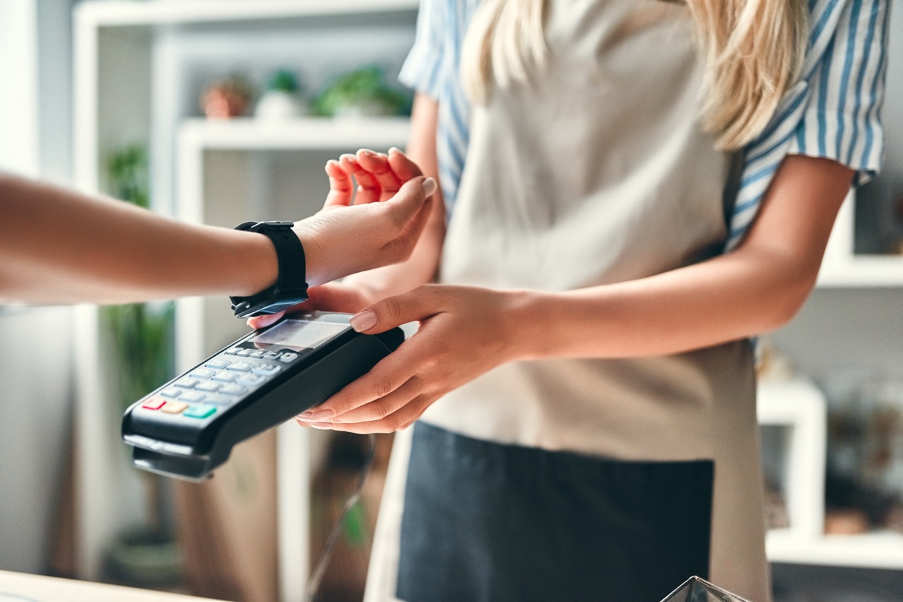 Customer paying by contactless card on a handheld terminal in store